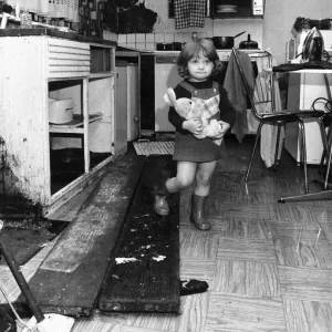 Interior view of a London terraced house showing a child in the kitchen March 1983