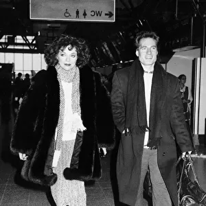 Joan Collins the actress with actor Neil Dickinson on their way to Los Angeles in