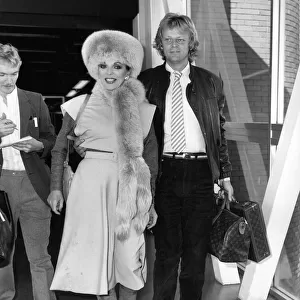 Joan Collins British Actress at Heathrow Airport with boyfriend Peter Holm in October