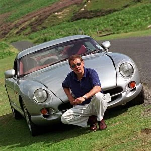 John Clelland sitting in front of a silver grey TVR Cerbera car August 1997