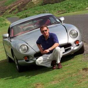 John Clelland sitting in front of a silver grey TVR Cerbera car August 1997