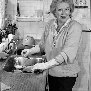 June Whitfield, TV actress, at her home in Wimbledon doing the washing up in her