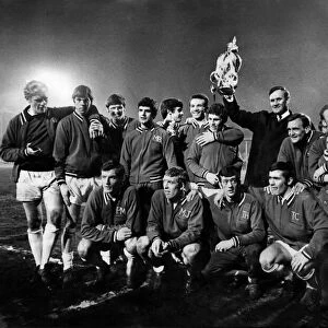 Leeds United manager Don Revie proudly holds the League Championship Trophy surrounded by