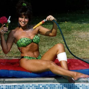 Linda Lusardi Model / TV Presenter sitting by poolside spraying water on to her chest