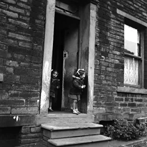 A little girl stands at the front door looking for mum in Bradford
