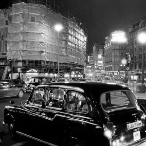 London taxis around Picadilly Circus at night. February 1987
