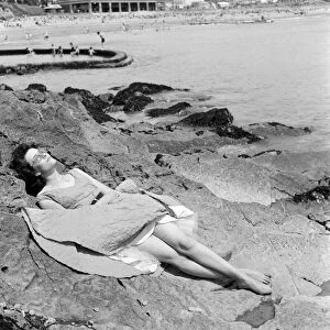 Londoner Pauline Weller, 20, sunbathes on the rocks at Porthcawl, Mid Glamorgan, Wales