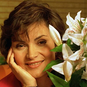 Lorraine Kelly TV presenter sitting next to green white plant