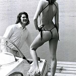 A man on his boat looks admiringly at model Carol Dwyer
