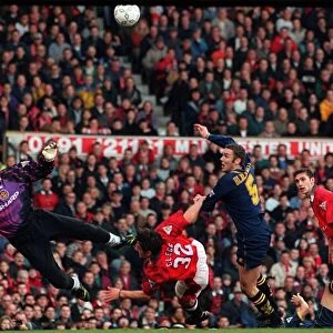 Manchester Uniteds goalkeeper Peter Schmeichel dives to save Wimbledons Dean Blackwell