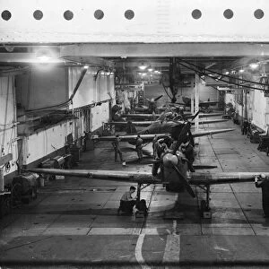 Mechanics working on the British Royal Navy aircraft carrier HMS Argus inside the hangar