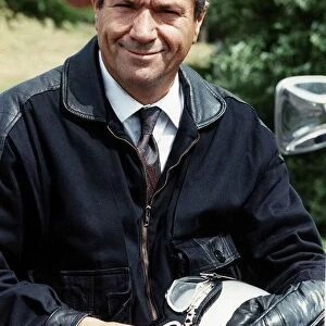 Michael Elphick sitting on motorcycle holding crash helmet