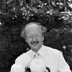 Michael Fish, BBC Weather man, pictured with a new strain of Chrysanthemum Flower that