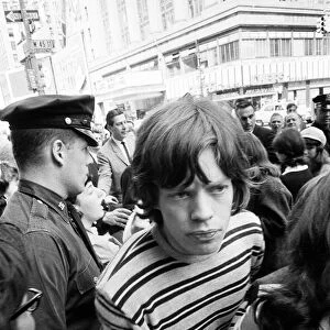 Mick Jagger of The Rolling Stones surrounded by fans on Broadway. 2nd June 1964