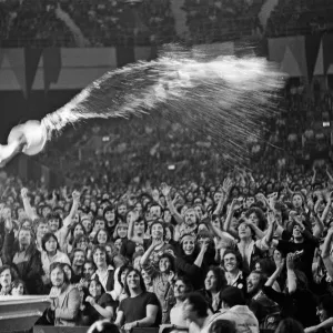 Mick Jagger throwing water over the crowd during a Rolling Stones performance at Earls