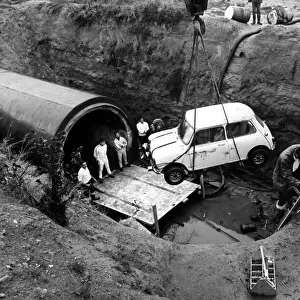 A Mini is lowered into Coventry sewers during the filming of "The Italian Job"