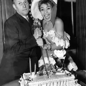 Black and white print of Shirley Bassey cutting a cake with Al Read Black and white print of Shirley Bassey cutting a cake with Al Read