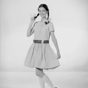 La modelo Jennifer Goddard. Niña morena con vestido a cuadros y coletas de cerdo. La modelo Jennifer Goddard. Niña morena con vestido a cuadros y coletas de cerdo.