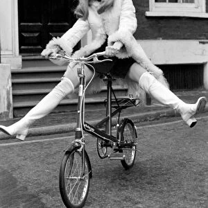 Model Blanche Webb wearing a fur jacket, riding a bicycle. November 1969 Z11350-015