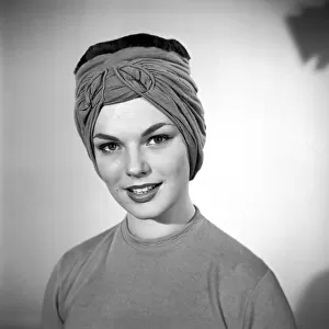 Model Mary Dixon wearing a hat that can be converted into a face mask. April 1956