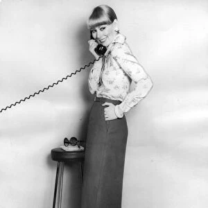 A model talking on the telephone wearing a pencil skirt