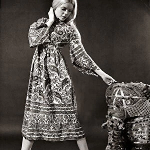 A model wearing a swirly print midi dress with wide bell sleeves made from Indian cotton