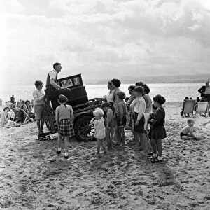 Mr Percy Tucker playing an ancient Barrel Organ on the beach of Exmouth