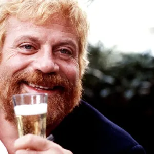 Oliver Reed drinks a glass of champagne 1986