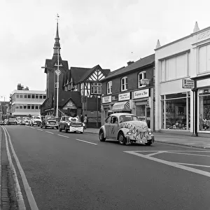 A parade of cars led by a decorated VW Beetle drive along Bridge Street, Stafford