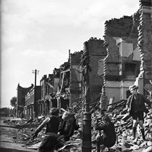 Picture shows young boys playing in the ruins of housing decimated in the Blitz of