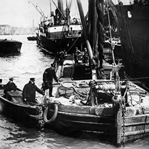 Police Centenary. Metropolitan river police bring their boat alongside a barge while one
