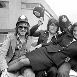 Pop Group "Mud". with police officer as they wear pilce helmets May 1975