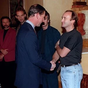 Prince Charles November 1992 shakes hands with musician Phil Collins as the rest of
