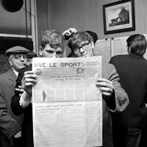 Punters studying the form guide in a French newspaper before placing their bets