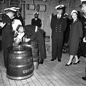 Queen Elizabeth II watches Victualling Officer B. R. Hailstone issuing the rum ration