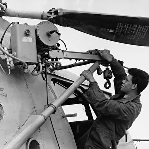 RAF ground crew member T Walton seen here checks the winch on a RAF Bristol Sycamore HR13