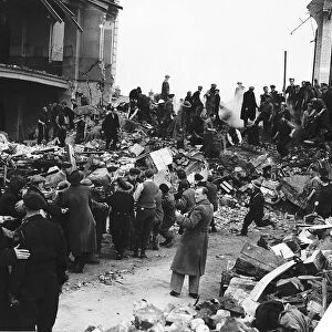 Rescuers search for survivors among the remains of school hit by a bomb during a WW2 air