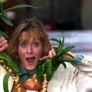 Sarah Lancashire actress poking her head through a plant