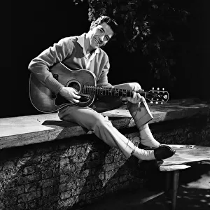 Singer Michael Holliday poses with guitar. 26th September 1958