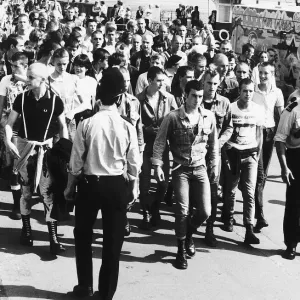 Skinheads being marched back to the railway station at Southend Essex where a strong