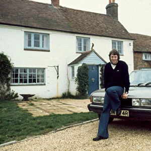 Southampton footballer Mick Channon pictured sitting on the bonnet of his car outside his