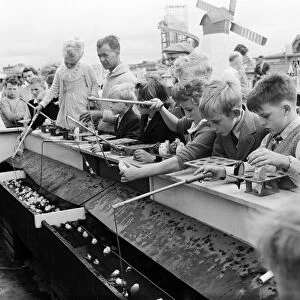 Southport, children fishing for lucky fish at the childrens fairground, Merseyside