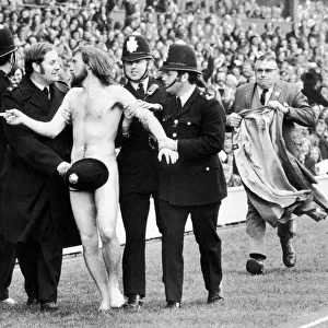 Streaker Michael O Brien sprints into the arms of awaiting policemen during half time