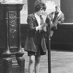 Sue Lloyd actress puts money in a parking meter May 1967 for her mini