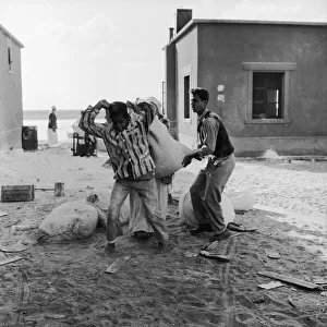 Suez Crisis 1956 Children carry off the leftovers after adults raided