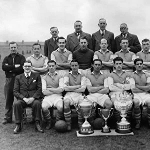Wigan Athletics football team poses for a group photograph with their three cups
