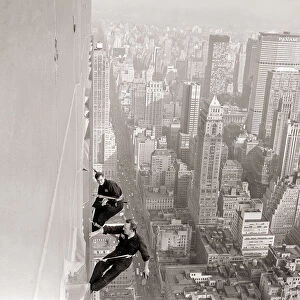 Window Cleaners a 1000 foot above the side walk cleaning the windows of the Empire State