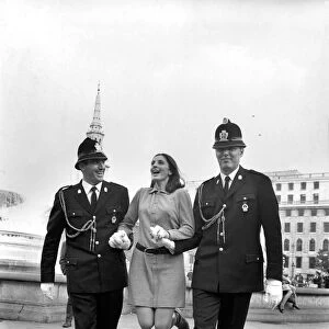 Woman being held up by two policemen in Trafalgar Square, London. October 1969 Z10351