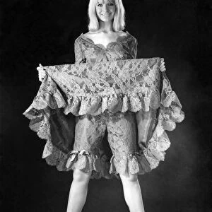 A woman showing off her underwear underneath her dress. December 1964