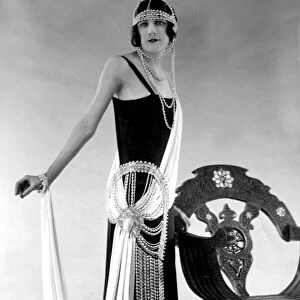 Woman wearing black dress with pearl bead detail at the waist and as a headdress